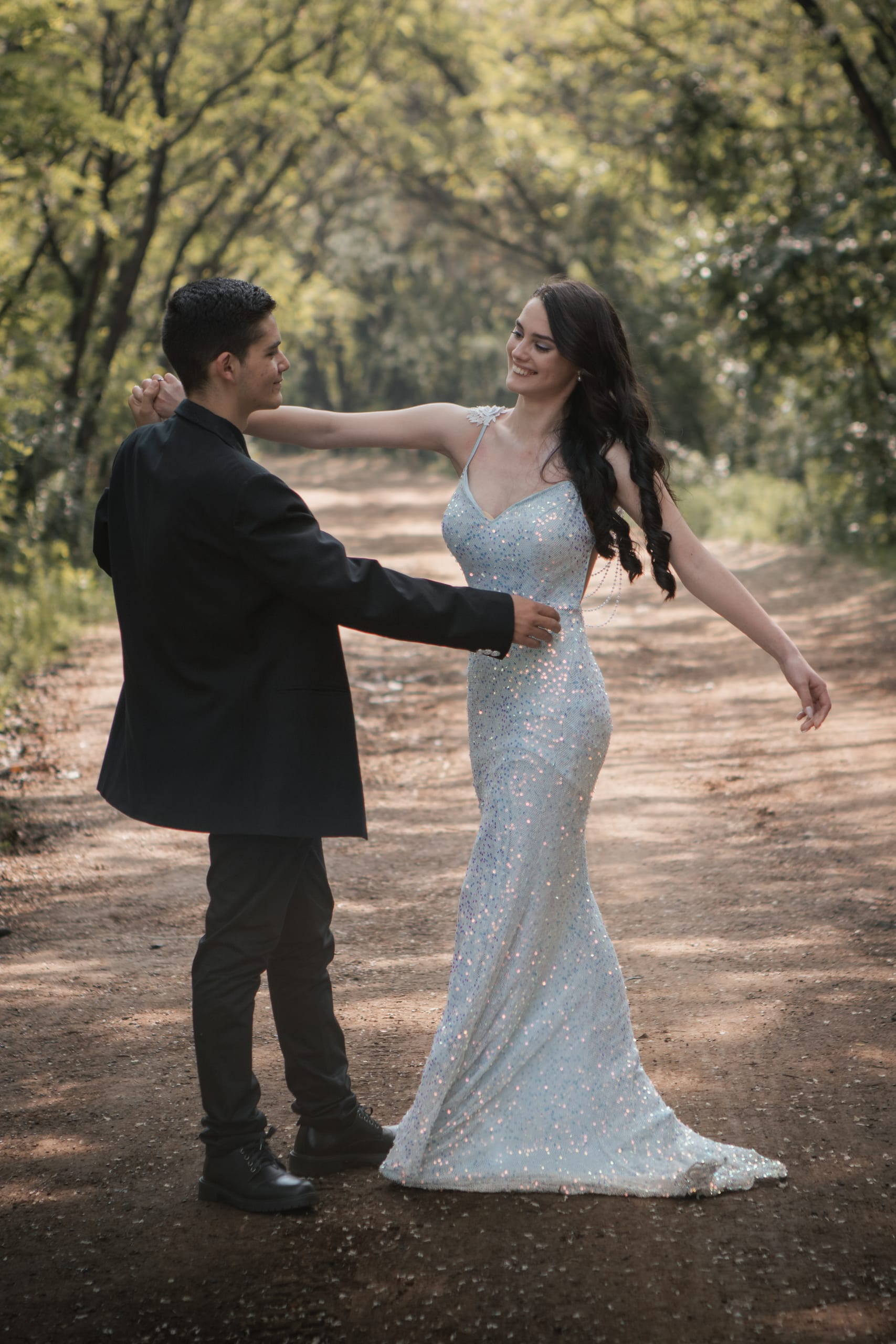 Matric farewell couple dancing together on a tree-lined path