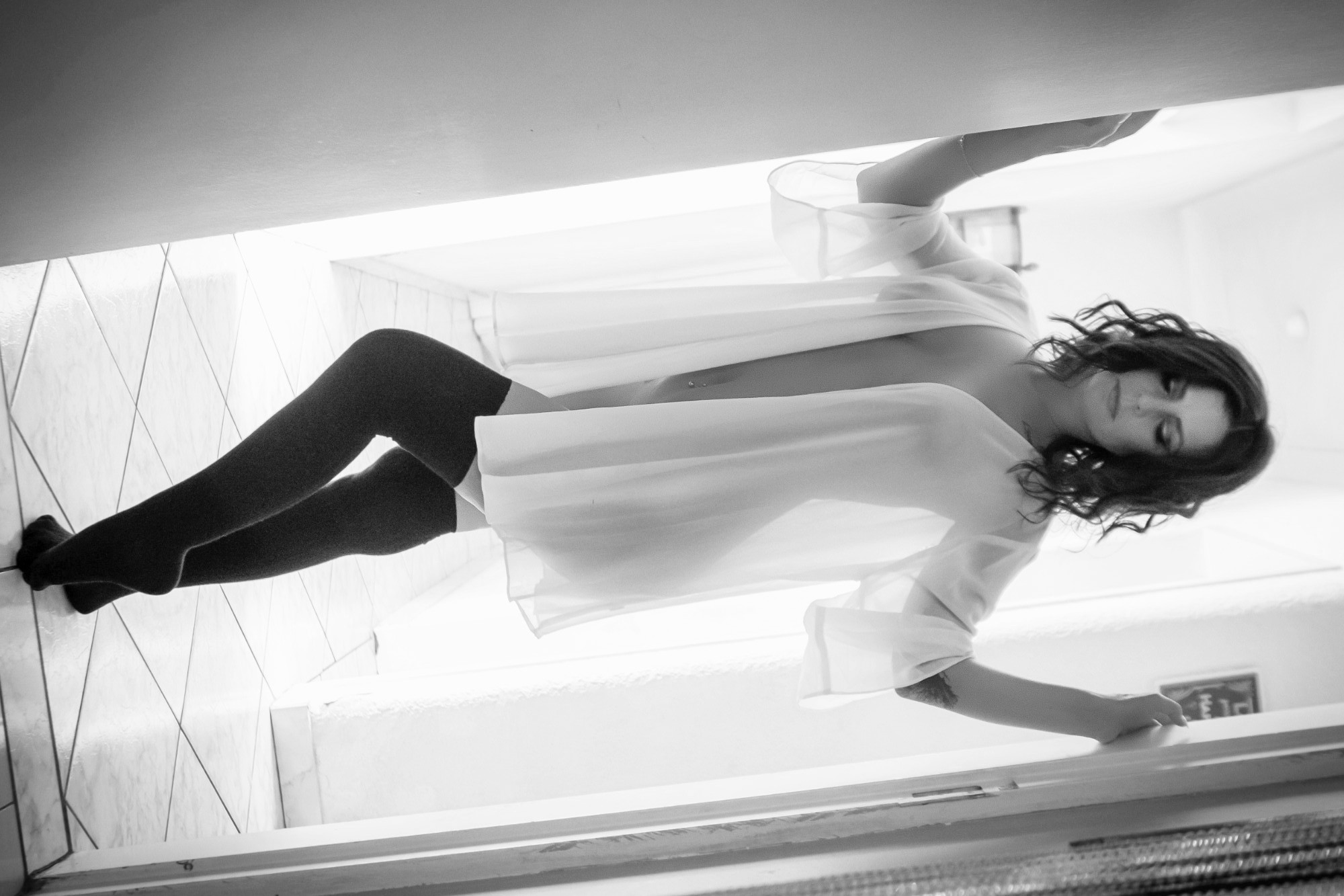 Boudoir portrait in a soft white robe in a hallway